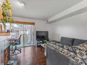 Living room with a desk and dark wood finished floors