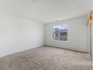 Carpeted spare room with baseboards