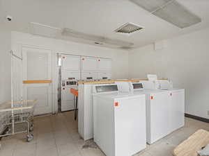 Communal laundry room featuring washing machine and dryer and stacked washer / dryer
