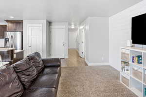 Living area featuring baseboards and light colored carpet