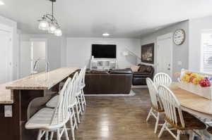 Dining space featuring dark wood-style floors and an accent wall