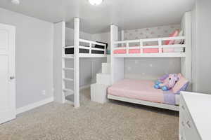 Bedroom featuring light colored carpet and baseboards
