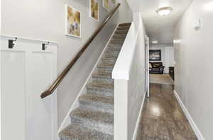 Stairway featuring wood finished floors and baseboards