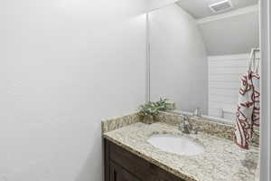 Bathroom with vanity and vaulted ceiling