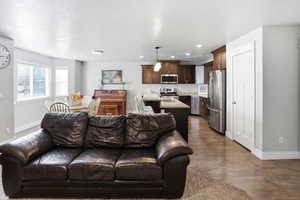 Living room with dark wood finished floors and recessed lighting