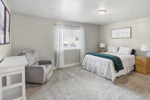 Primary Suite Carpeted bedroom featuring baseboards and a textured ceiling