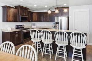 Kitchen featuring stainless steel appliances, a kitchen breakfast bar, a center island, dark wood finish cabinets, and a textured ceiling