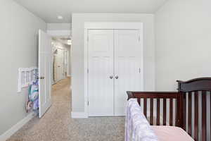 Bedroom featuring a closet and light colored carpet
