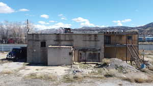 Rear view of property with a mountain view and concrete block siding