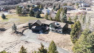 Aerial view of property and surrounding area featuring a tree filled landscape