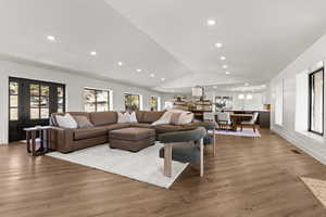 Living area featuring wood finished floors, vaulted ceiling, and recessed lighting