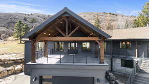 Back of house featuring a mountain view, a garage, and a patio area