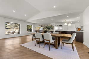 Dining room featuring light wood finished floors, vaulted ceiling, and recessed lighting