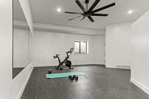 Workout area featuring dark rubber floors, ceiling fan, and recessed lighting