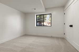 Unfurnished bedroom featuring light colored carpet and baseboards