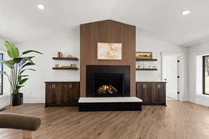 Living area with a fireplace, recessed lighting, and light wood-style floors
