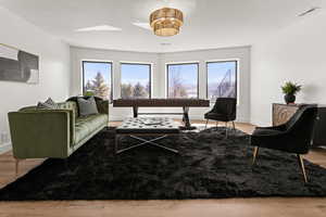 Living area featuring light wood-type flooring and a textured ceiling
