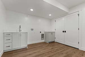 Laundry area with cabinet space, washer hookup, dark wood-style floors, and recessed lighting