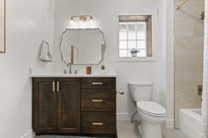 Full bath with vanity, washtub / shower combination, and light tile patterned floors