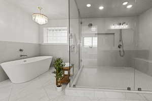 Full bath with a shower stall, a freestanding bath, a wainscoted wall, marble finish floors, and recessed lighting