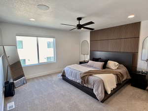 Carpeted bedroom featuring a textured ceiling, a ceiling fan, and recessed lighting