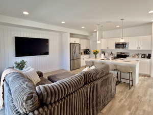 Living area with light wood-style floors and recessed lighting