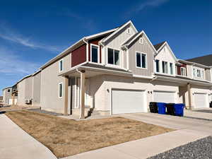 View of front of property featuring a garage, concrete driveway, and brick siding