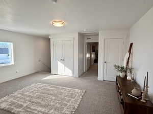 Bedroom featuring a closet, light colored carpet, and a textured ceiling