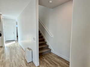 Stairway featuring wood finished floors and baseboards