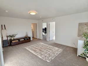 Living area with baseboards and light colored carpet