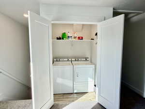 Laundry area featuring washer and dryer and light wood-type flooring