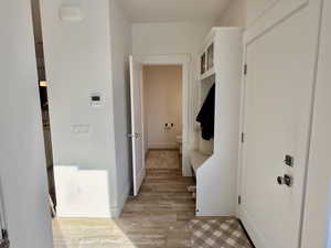 Mudroom with light wood finished floors and baseboards