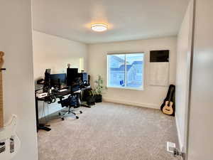 Carpeted office space featuring baseboards and a textured ceiling
