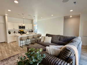 Living area featuring light wood-style flooring and recessed lighting