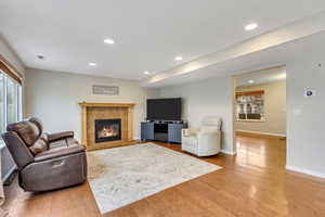 Living room featuring healthy amount of natural light, light wood-style floors, a tile fireplace, and recessed lighting