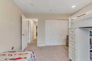Unfurnished bedroom featuring light colored carpet and a closet