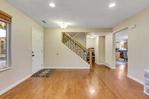 Foyer featuring light wood-style flooring, a textured ceiling, and recessed lighting