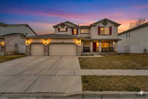 Traditional home featuring a porch, stucco siding, concrete driveway, stone siding, and a garage
