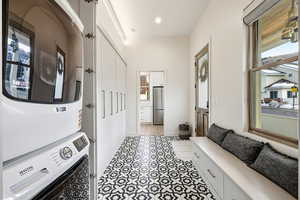 Laundry area with stacked washer / drying machine and recessed lighting