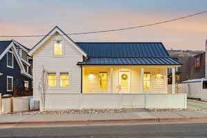 View of front of house with a porch and a standing seam roof