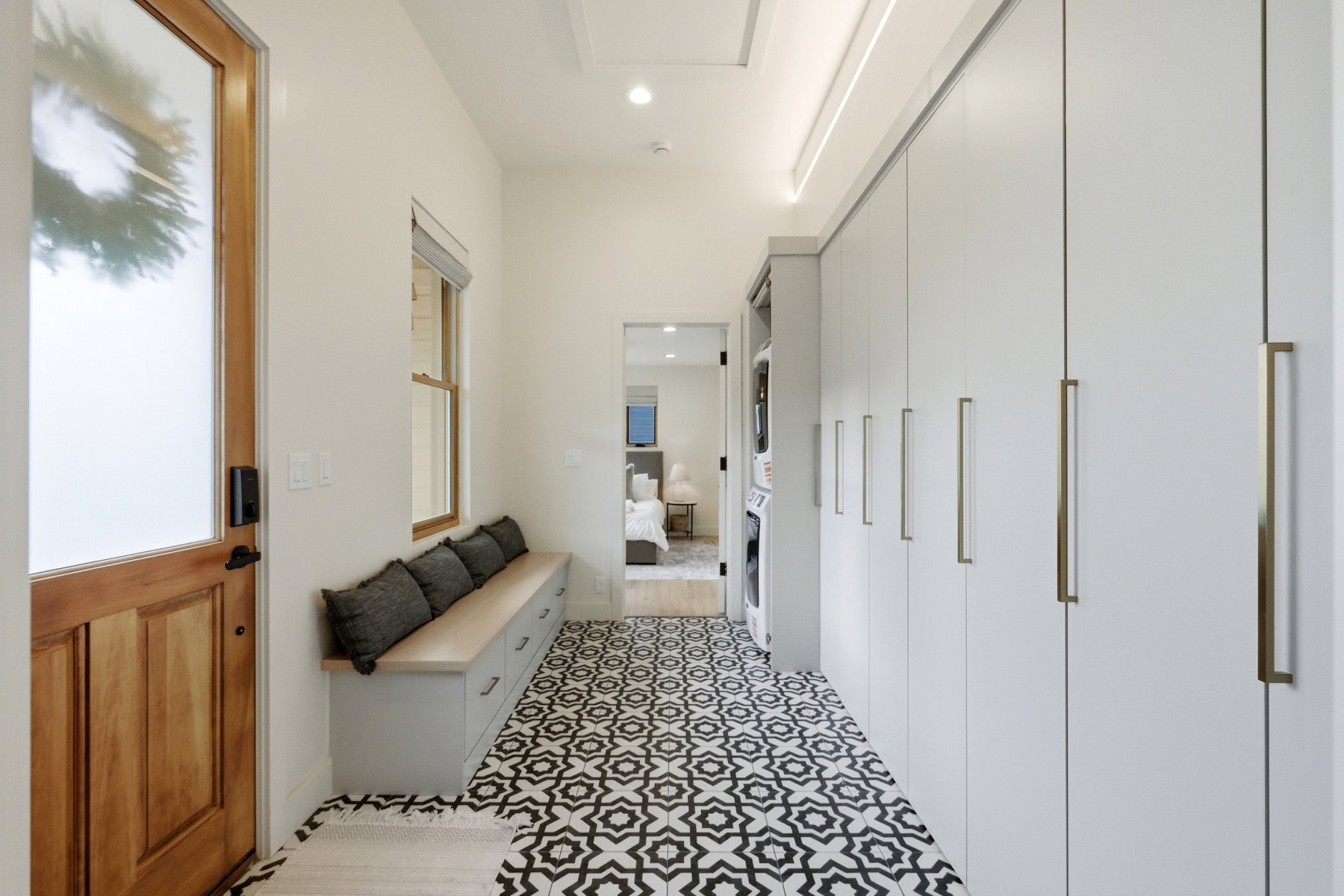 Mudroom with recessed lighting and stacked washing machine and dryer