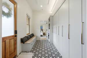 Mudroom with recessed lighting and stacked washing machine and dryer