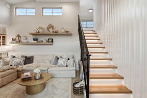 Living room featuring stairway and a high ceiling
