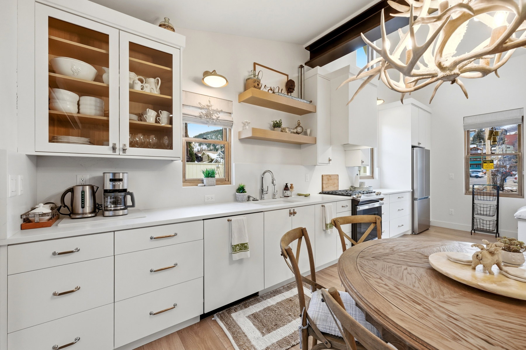 Kitchen featuring light countertops, white cabinets, stainless steel appliances, and light wood-type flooring