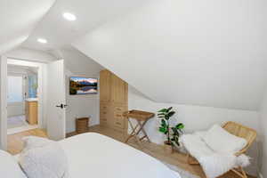 Bedroom with lofted ceiling, light wood finished floors, and recessed lighting