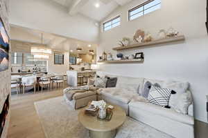 Living area featuring light wood-style flooring, lofted ceiling, and recessed lighting