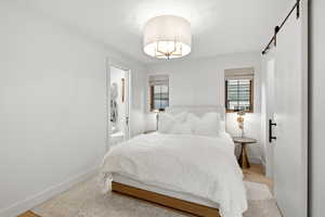Bedroom with a barn door and connected bathroom