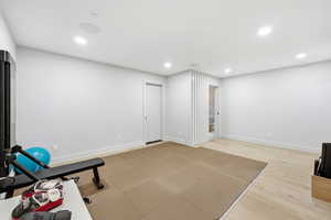 Exercise area featuring light wood-style flooring and recessed lighting