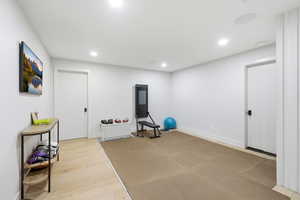 Workout area featuring light wood-type flooring and recessed lighting