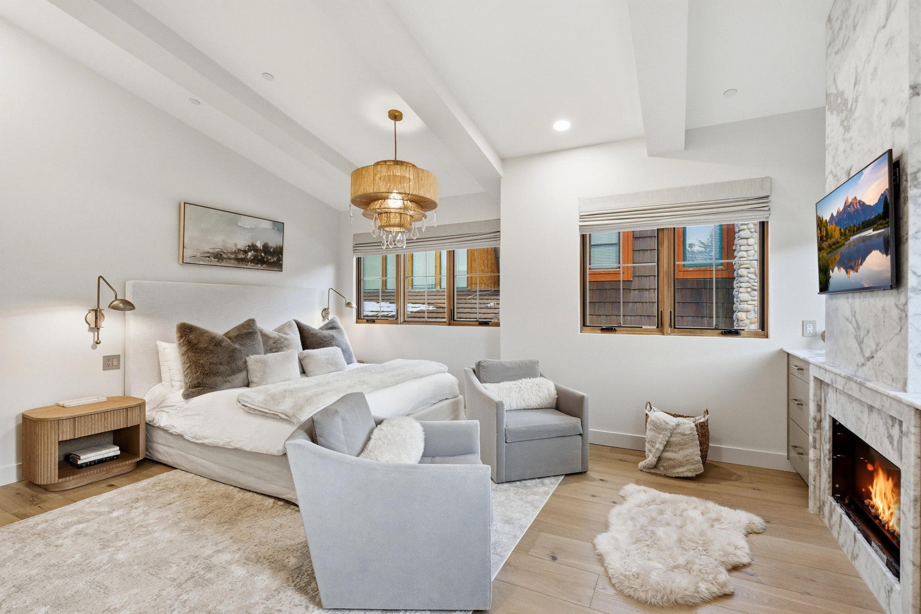 Bedroom with beam ceiling, light wood finished floors, a high end fireplace, and recessed lighting